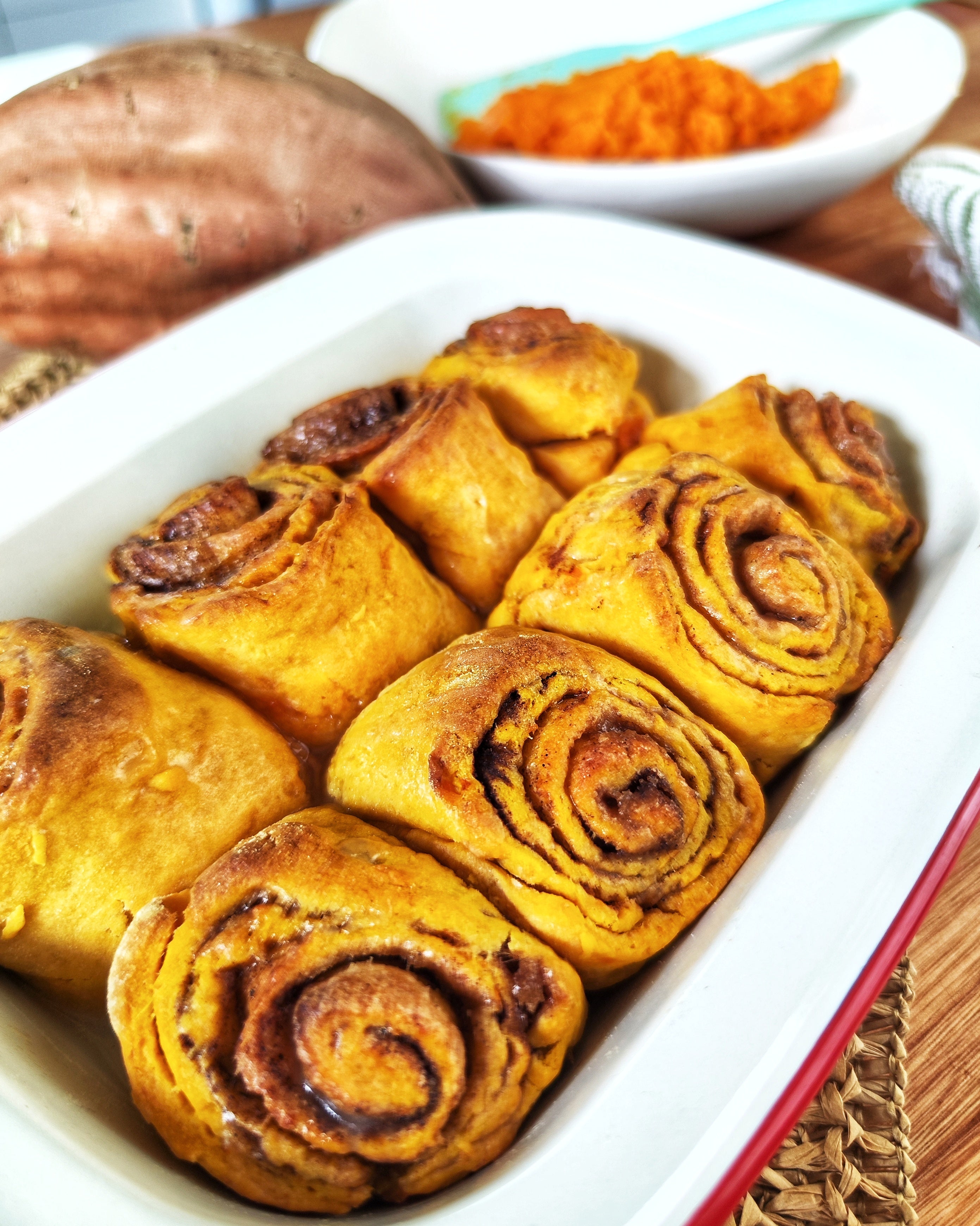 Golden sweet potato cinnamon rolls topped with a light icing glaze