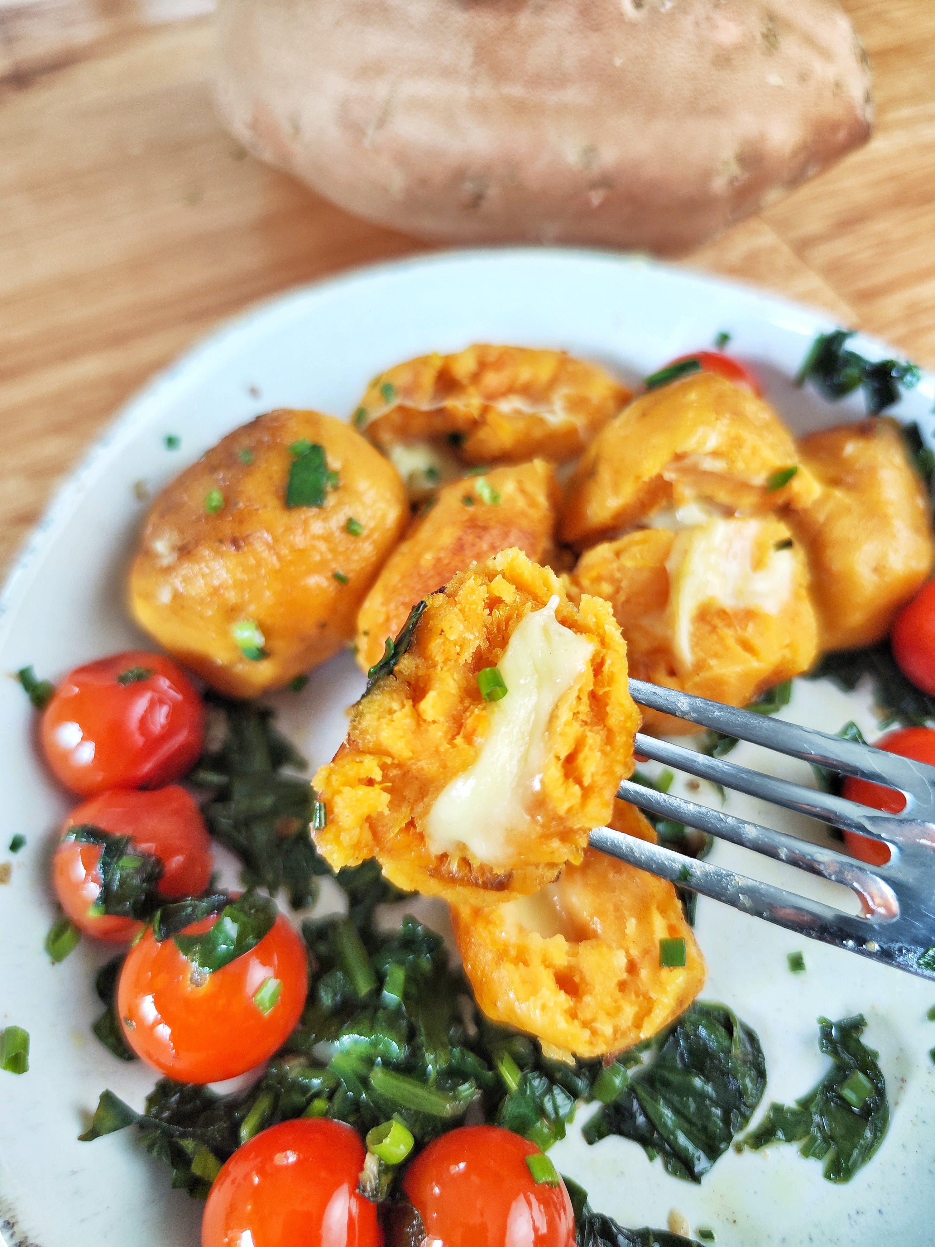 Homemade kumara gnocchi stuffed with mozzarella and served with cherry tomatoes and kale.
